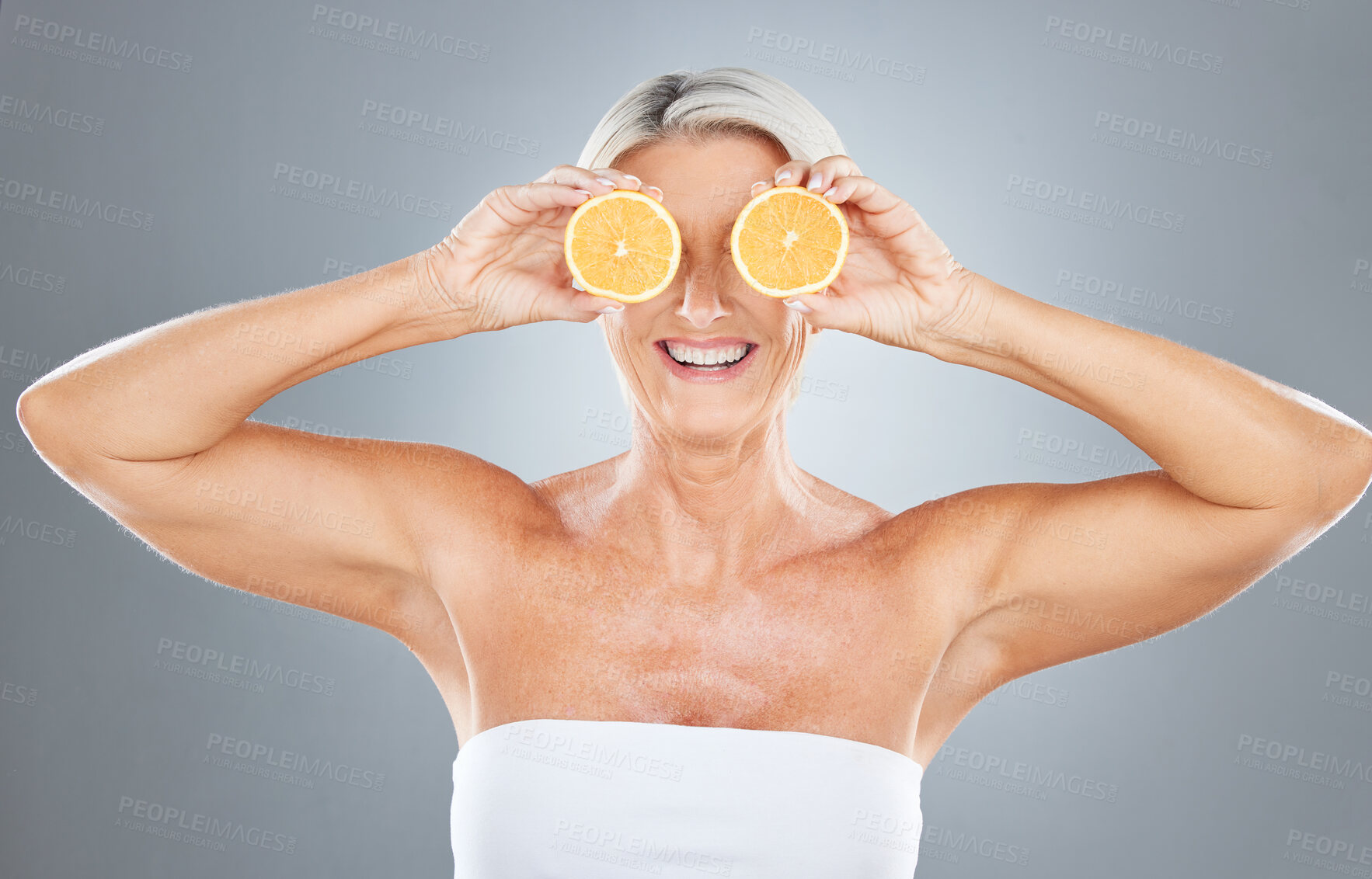Buy stock photo Beauty, skincare and orange with a model mature woman in studio on a gray background for health or wellness. Food, fruit and natural with an elderly female posing to promote nutrition or luxury