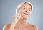 Beauty, skincare and jade roller by senior woman in studio for facial, skin and wellness on grey background mockup. Face, massage and roller by elderly skin model relax, happy and wrinkles product