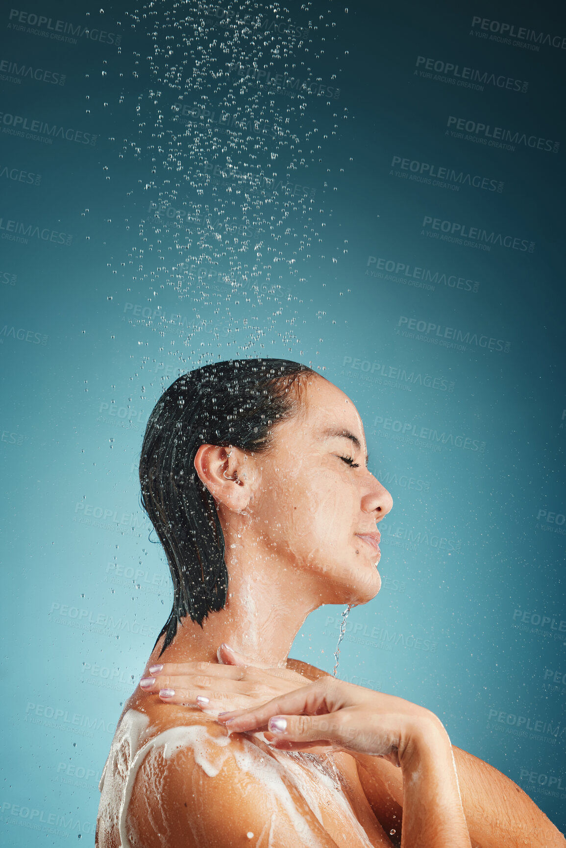 Buy stock photo Shower, water splash and woman cleaning, hair and wellness, grooming and hair care in a studio with mockup. Beauty splash, relax and hair care by asian girl cleaning, skin and hair on blue background