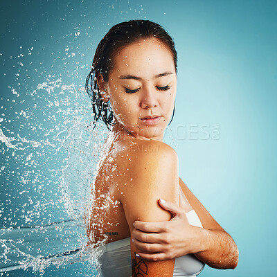 Buy stock photo Water, shower and washing with a woman in studio on a blue background for hygiene or hydration. Cleaning, cleansing and bathroom with an attractive young female in the bathroom for body care