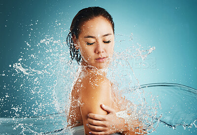 Buy stock photo Splash, water and woman in the shower to clean body against blue studio background. Skincare, relax and girl model with liquid for cleaning, wellness with hydration and hygiene for health and beauty