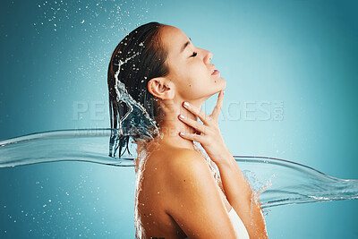 Buy stock photo Splash, water and woman with care for body, cleaning and in shower against a blue mockup studio background. Spa, health and Asian model with natural liquid to clean skin for wellness and beauty