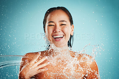 Buy stock photo Happy, water splash and woman in studio for skincare, cleaning and beauty on a blue background mock up. Facial, beauty splash ad asian model relax with water, product and skin, face and wellness 