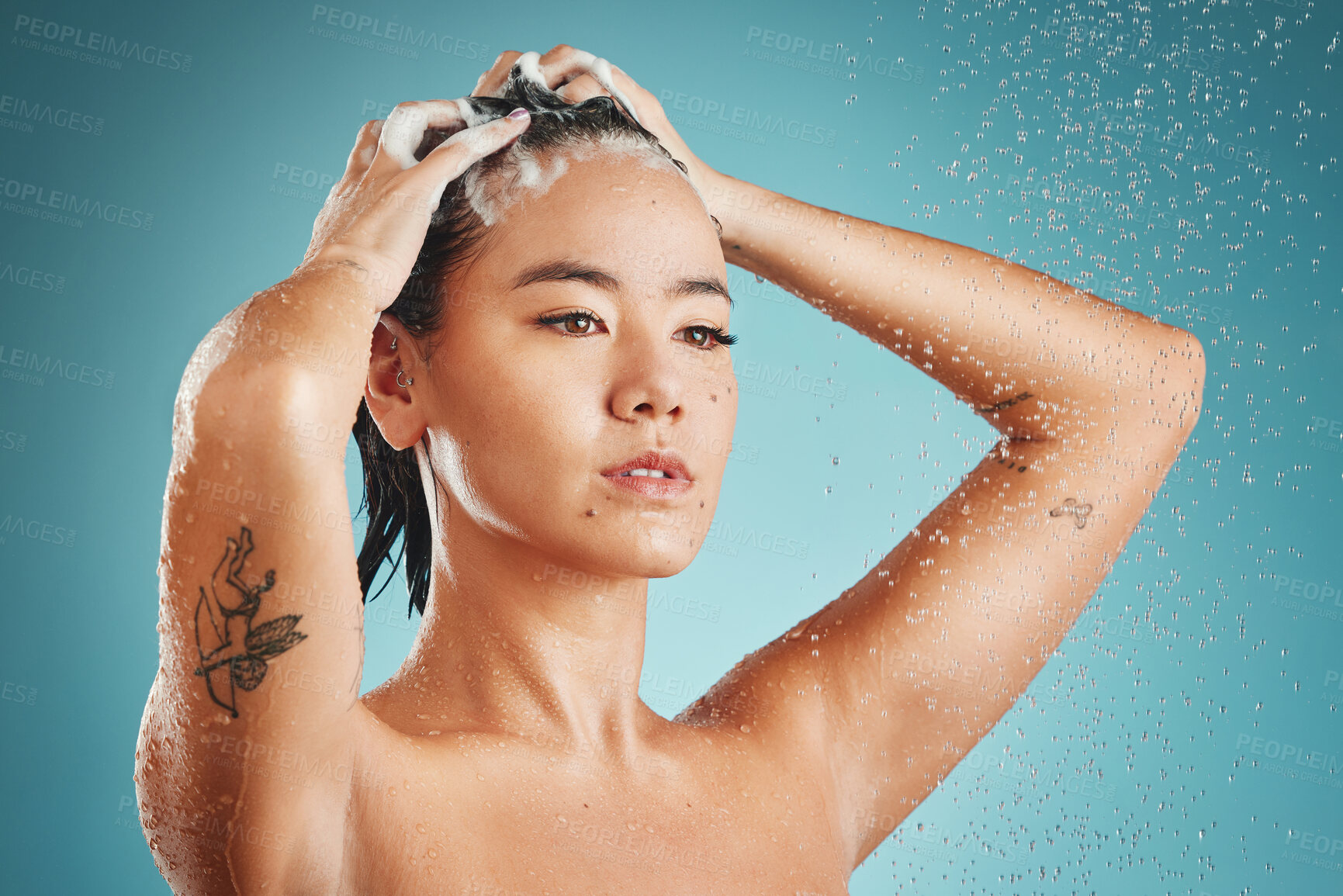 Buy stock photo Asian woman, beauty and shower with water, shampoo and wash against a blue studio background. Female skincare, cleaning and fresh skin, with body wellness, hydration and health with washing hair