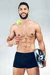 Fitness, health and man with smile for apple, scale and lifestyle balance against grey studio background. Gym, exercise and portrait of happy, healthy and athlete with fruit for nutrition and weight