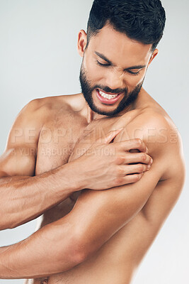 Buy stock photo Beauty, body and injury with a man model holding his shoulder in pain in studio on a gray background. Fitness, health and anatomy with a young male suffering with muscle cramp, ache or inflammation