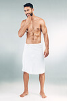 Man, shower and body grooming in towel for beauty, care and relax wellness. Portrait of young model, happy skincare and luxury body care cleaning or skin cosmetic treatment in white studio background