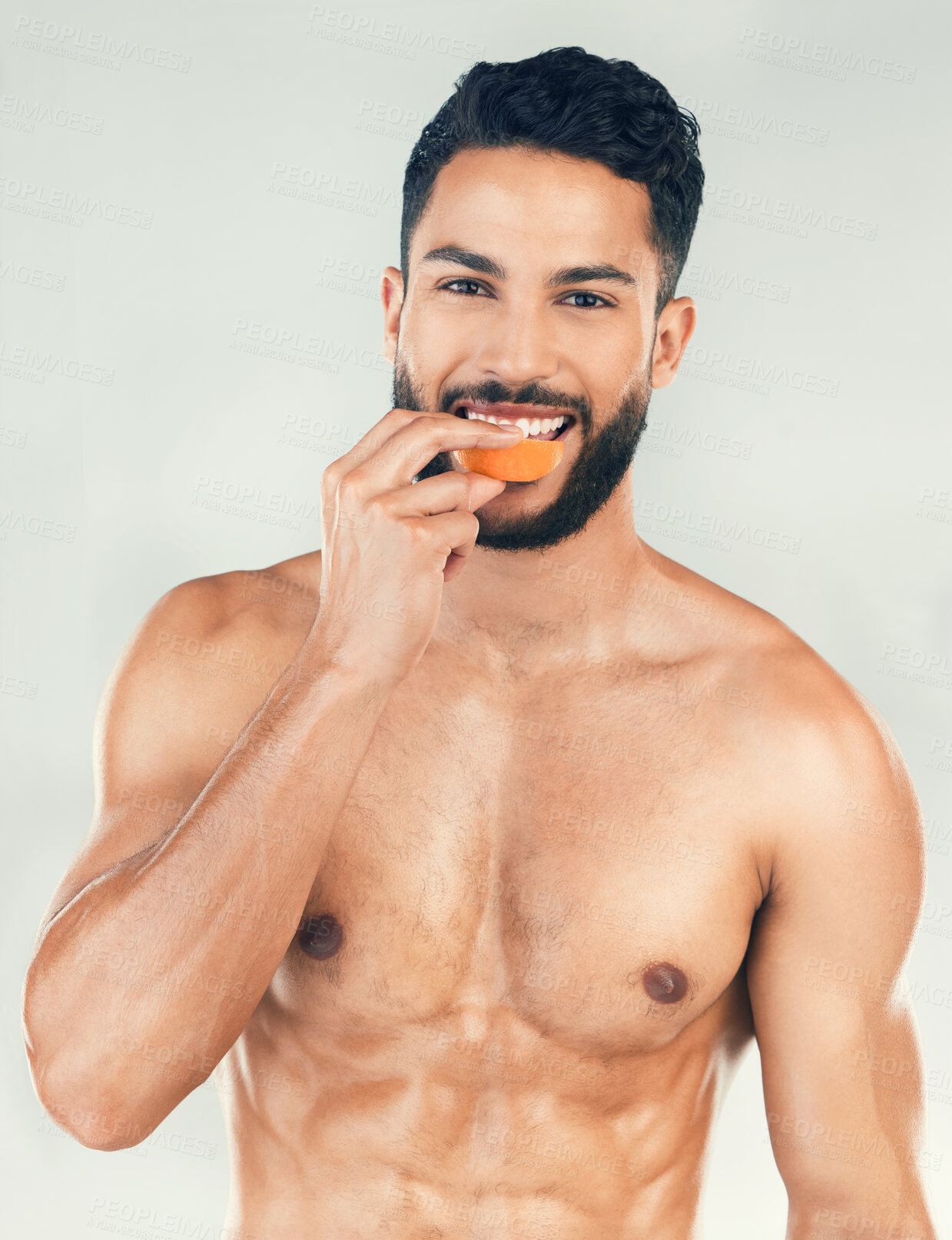 Buy stock photo Portrait, fitness and man eating an orange in studio for vitamin c, healthy skin and self care after training. Nutrition, wellness and happy fitness model on a diet enjoys raw fruit after a workout
