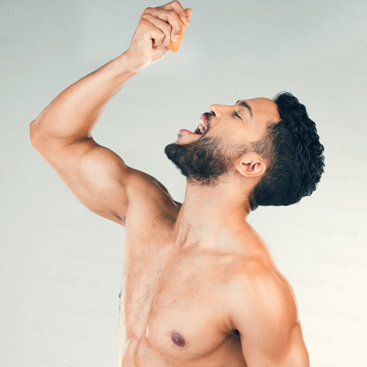 Buy stock photo Orange, juice and man eating fruit for health, nutrition and clean diet against a grey studio background. Citrus, food and healthy person with smile and happy about vitamin c for care for body