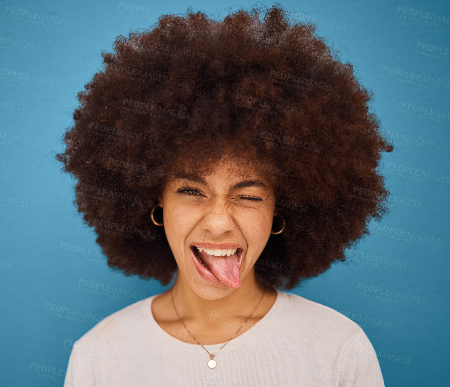 Buy stock photo Face, portrait and woman with tongue out being silly and goofy on a blue studio background. Amusing, comic and crazy african american female making a funny, humour face on a backdrop
