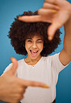 Black woman, hand frame afro and studio beauty with wink, smile and comic pose by blue background. African model woman, sign hands and funny portrait with happy face, photography and play by backdrop