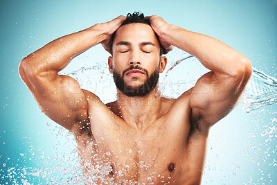 Buy stock photo Water splash, skincare and man taking a shower, cleaning and washing body for health, wellness and hygiene against a blue background. Male doing self care routine for skin and face for natural care