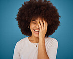 Face, funny and laughing with an afro black woman in studio on a blue background for fun or humor. Smile, comic and happy with an attractive young female feeling positive with joy or comedy