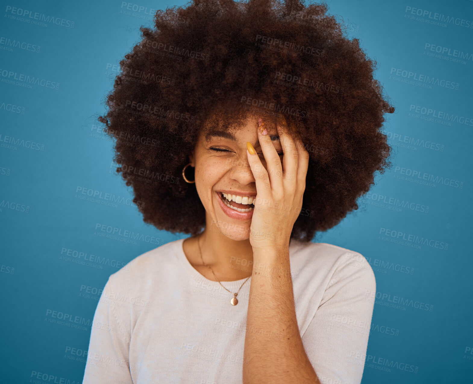 Buy stock photo Face, funny and laughing with an afro black woman in studio on a blue background for fun or humor. Smile, comic and happy with an attractive young female feeling positive with joy or comedy