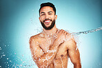 Man, skincare and water splash shower in studio for wellness, health and grooming in blue background mockup. Cleaning, skin and beauty with model washing hygiene and relax, pamper or body in bathroom