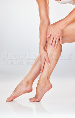 Buy stock photo Woman, hands and legs in skincare for moisturizer, smooth or soft natural care against a white studio background. Female hand touching leg to moisturize, creme or lotion for skin cosmetic treatment