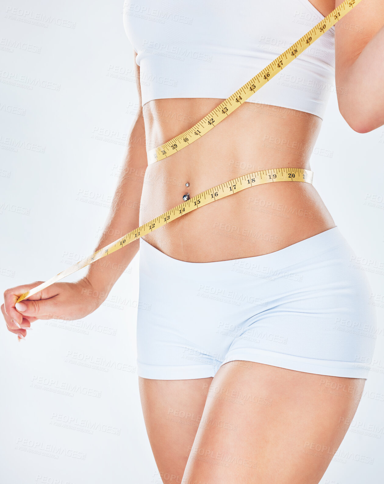 Buy stock photo Body, tape measure and diet with a woman measuring her waist to track weightloss in studio on a gray background. Fitness, health and wellness with a young female mentoring her diet for losing weight