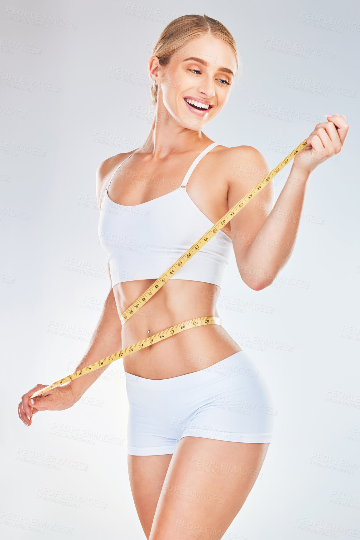 Buy stock photo Happy, woman and tape measure for weight, diet and check fitness progress against a white mockup studio background. Model smile for weight loss, health and healthy body with slim waist after workout