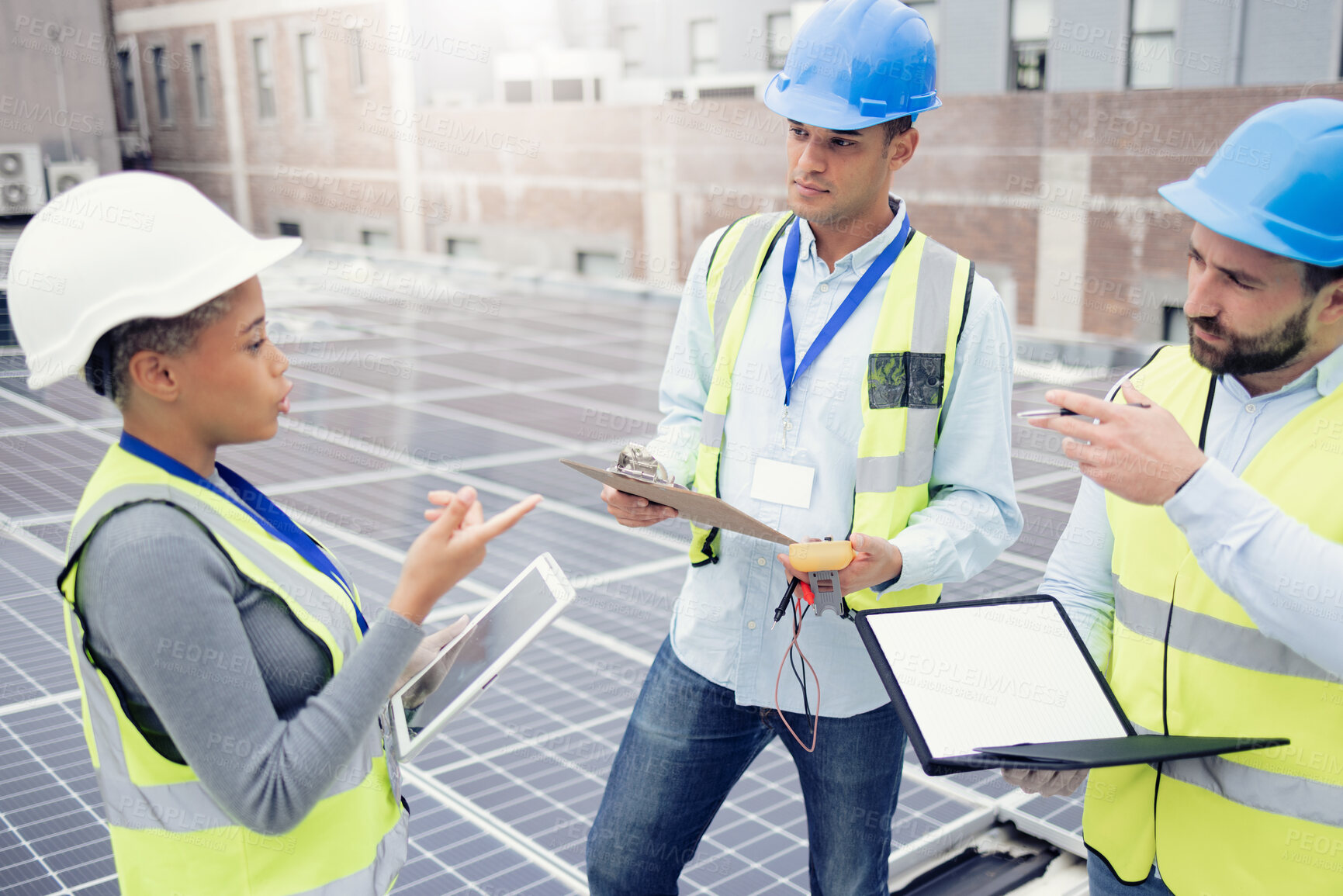 Buy stock photo Tablet, solar energy and teamwork with an engineer, designer and technician meeting on a roof in the city for renewable energy. Engineering, solar panel and energy with a man and woman group at work