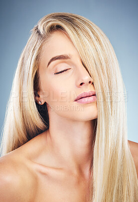 Buy stock photo Face, beauty and hair care of woman with eyes closed isolated on blue background in studio. Aesthetic, luxury makeup or skincare of female model with long, blonde or healthy hair after hair treatment