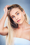 Face portrait, beauty and hair care of woman in studio isolated on blue background. Makeup cosmetics, skincare and aesthetic of blonde female model from Canada with healthy hair after salon treatment