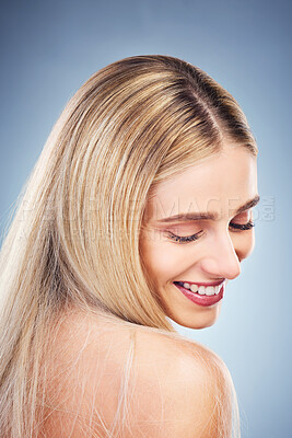 Buy stock photo Beauty, hair and wellness model happy with glossy, shiny and healthy cosmetic product. Blonde hair, happiness and smile of young woman for hair care marketing in gray studio background.

