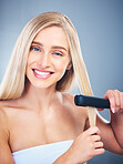 Portrait of blonde happy woman, flat iron aesthetic for beauty salon and healthy hair care with natural smile. Young model with clean hair shine, studio with blue background and cosmetic heat tool