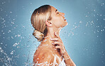Skincare, water and profile of woman on blue background in studio for beauty, facial and wellness. Hydration, skincare products and girl model for washing, cleaning and  body cleanse at luxury spa