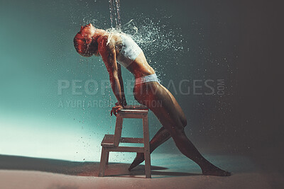 Buy stock photo Water, sexy and chair with a woman in studio or on stage during a theatre show for entertainment. Splash, performance and wet with an attractive young female on a color background for theater