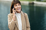 Happy, senior woman and phone call for conversation, discussion and with smile outdoor. Retirement, mature female and confident lady with smartphone for talking, communication and speaking to connect