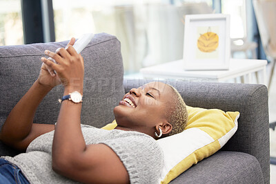 Buy stock photo Black woman, phone and lying on sofa in house or home living room with fun esports game, internet news or social media. Smile, happy or relax person on mobile digital technology or online dating app