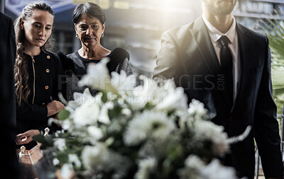 Buy stock photo Funeral, coffin and family or friends at death, mourning and church burial event sad together. Depression, grief and christian religion gathering of people and women with support with flowers