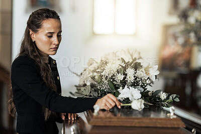 Buy stock photo Funeral, sad and woman with flower on coffin after loss of a loved one, family or friend. Grief, death and young female putting a rose on casket in church with sadness, depression and mourning