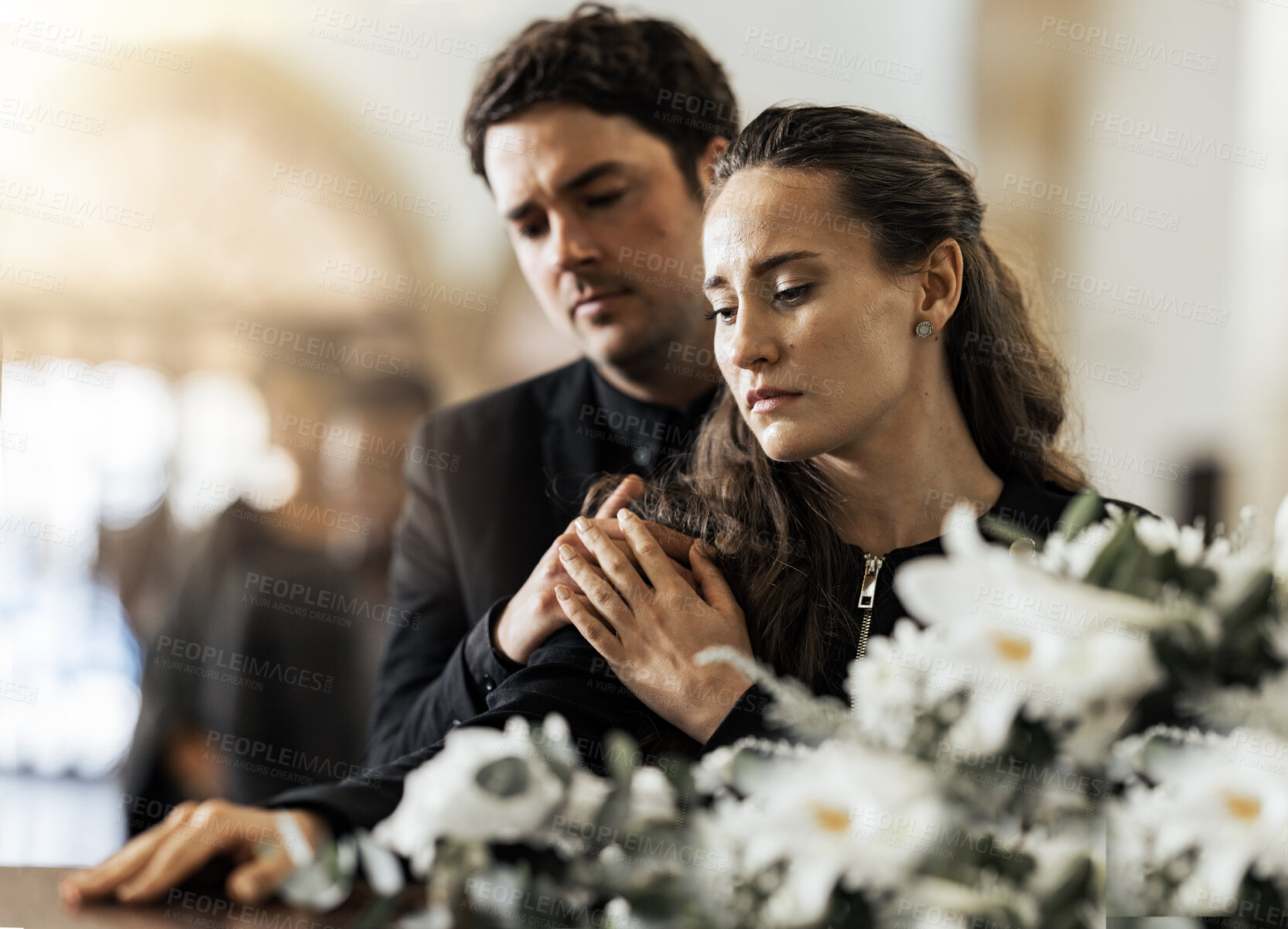 Buy stock photo Sad, funeral and flowers with couple and coffin in church for death, respect and mourning. Grief, goodbye and empathy with man and woman loss at casket with depression, remember and farewell memorial