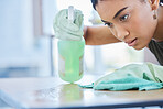 Clean, spray and woman cleaning a table at home for hygiene with a spray bottle product for fresh house. Housework, chores and face of female doing domestic cleansing with a cloth or rag on surface 