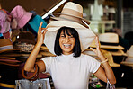 Woman, hats and smile of a black woman shopping at a retail store with a comic smile. Portrait of a funny and happy sales customer laughing from luxury shop experience in a mall or clothes boutique 