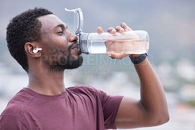 Buy stock photo Fitness, drinking water and black man in outdoor nature for exercise, training and running with music, audio streaming service. Tired runner, sports or athlete man with water bottle for workout