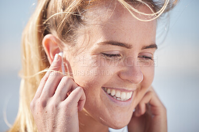Buy stock photo Face, happy and music with a woman listening to audio through earphones outdoor during the day. Podcast, head and closeup with an attractive young female streaming the radio while standing outside
