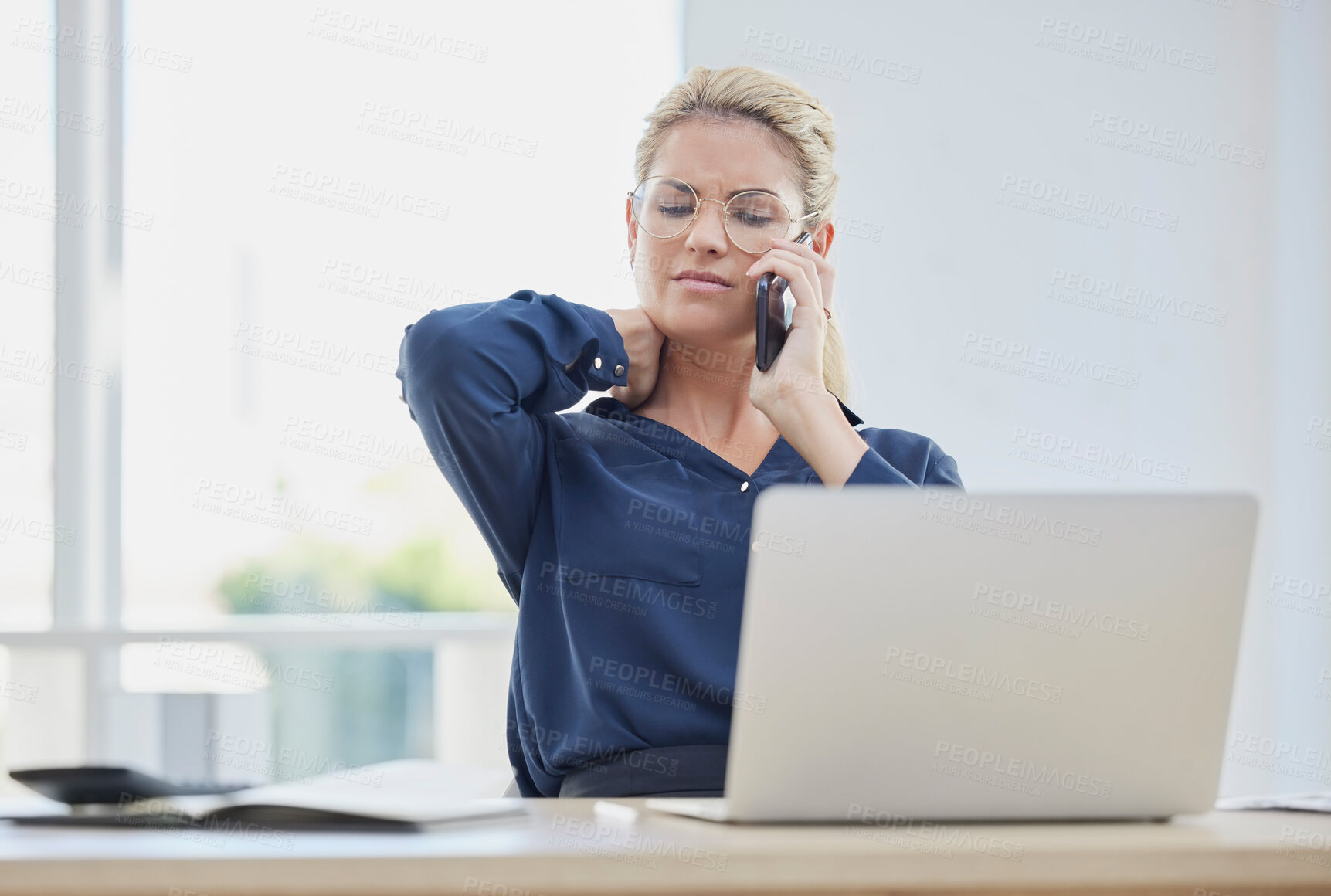 Buy stock photo Phone call, stress and neck pain with a business woman at work on a laptop in her office alone. Computer, posture and communication with a female employee working or talking on a mobile at her desk