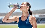 Drinking water, sports and woman athlete on an outdoor exercise field for training and fitness. Wellness, women workout and person thirsty in the sun relax after a runner challenge with a bottle