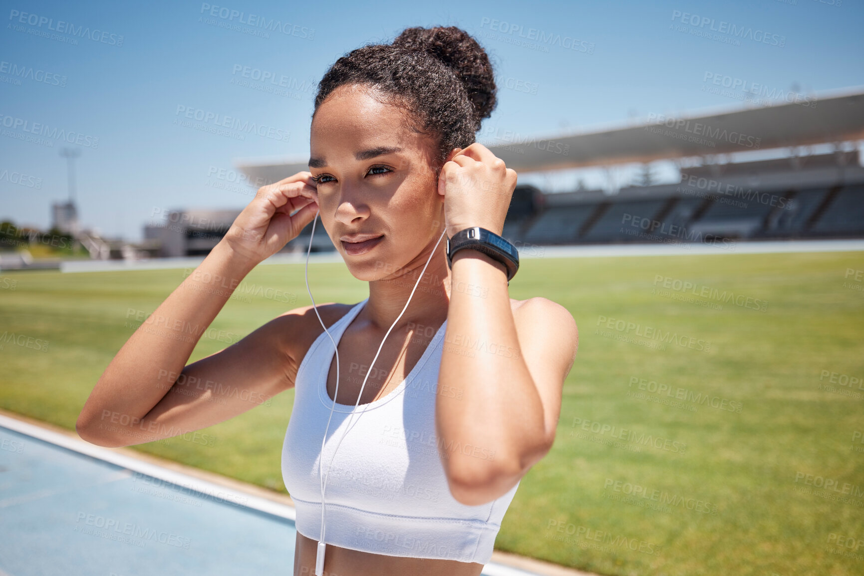 Buy stock photo Fitness, music and exercise with a sports black woman listening to audio while track running or training. Workout, health and cardio with a female runner or athlete streaming the radio with earphones