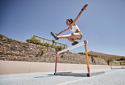 Runner, fitness and girl stadium jump for athlete hurdle training, workout or competition race. Challenge, running and power performance of athletic black woman on sports ground with sky mockup.