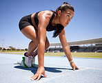 Running, sports and athlete in a race or marathon at an outdoor run track with start block. Motivation, fitness and woman runner getting ready to run for competition, exercise or training at stadium.