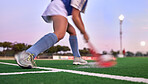 Sports, hockey and hit with woman on field for training, fitness and goals exercise. Challenge, action or power with shoes of hockey player in stadium for competition, performance and athlete workout