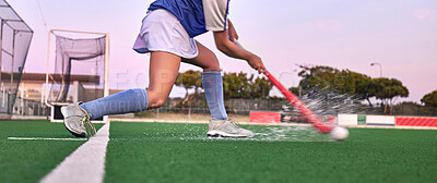 Hockey, stick and ball with a water splash on grass during exercise, training and fitness workout for a game, competition or match. Legs of athlete on sports field for goal, challenge and battle