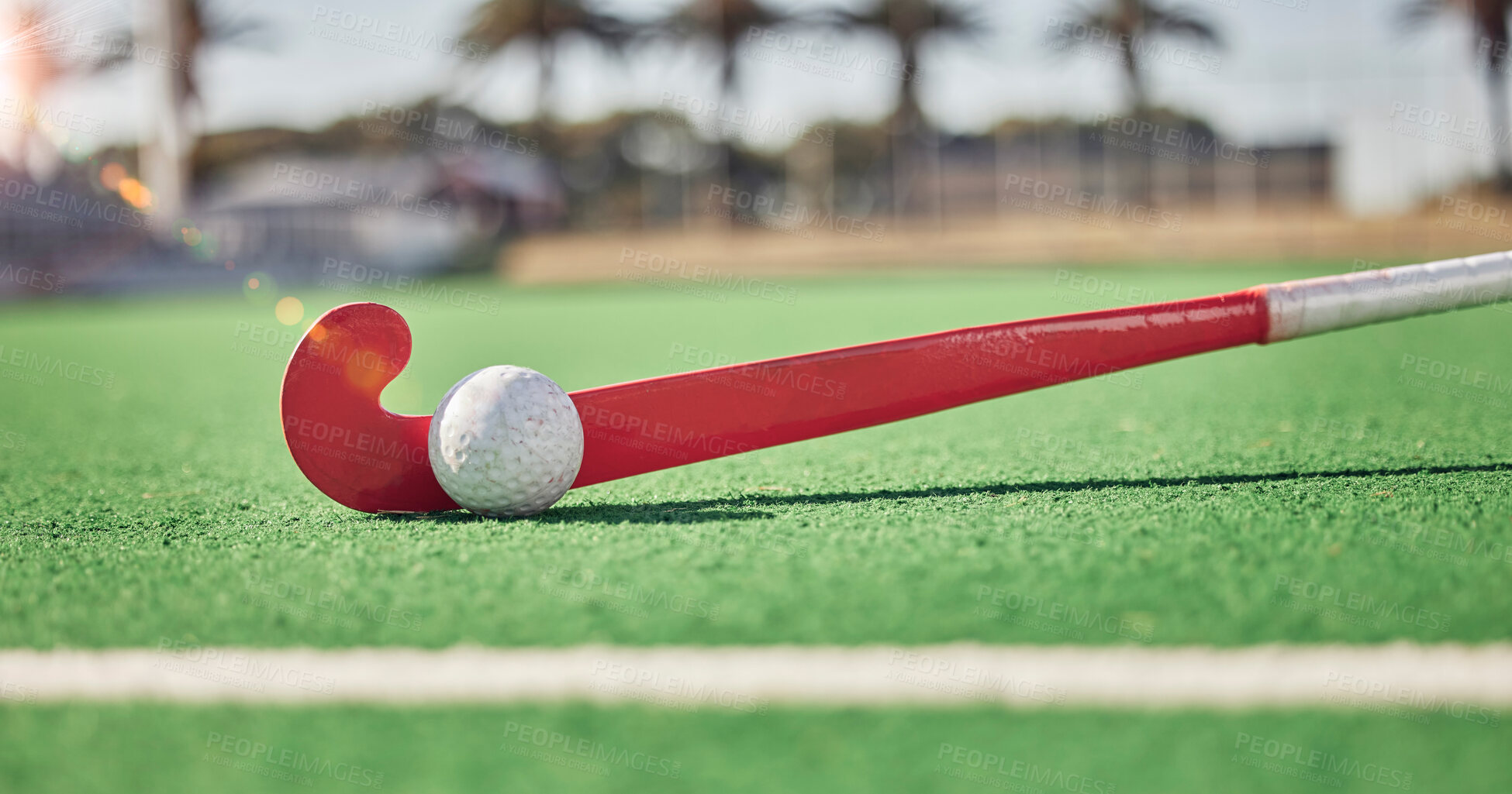 Buy stock photo Closeup, hockey and hockey stick with ball on field in sunshine for sport, contest or competition in summer. Sports, turf pitch and artificial grass on ground for exercise, workout and training game