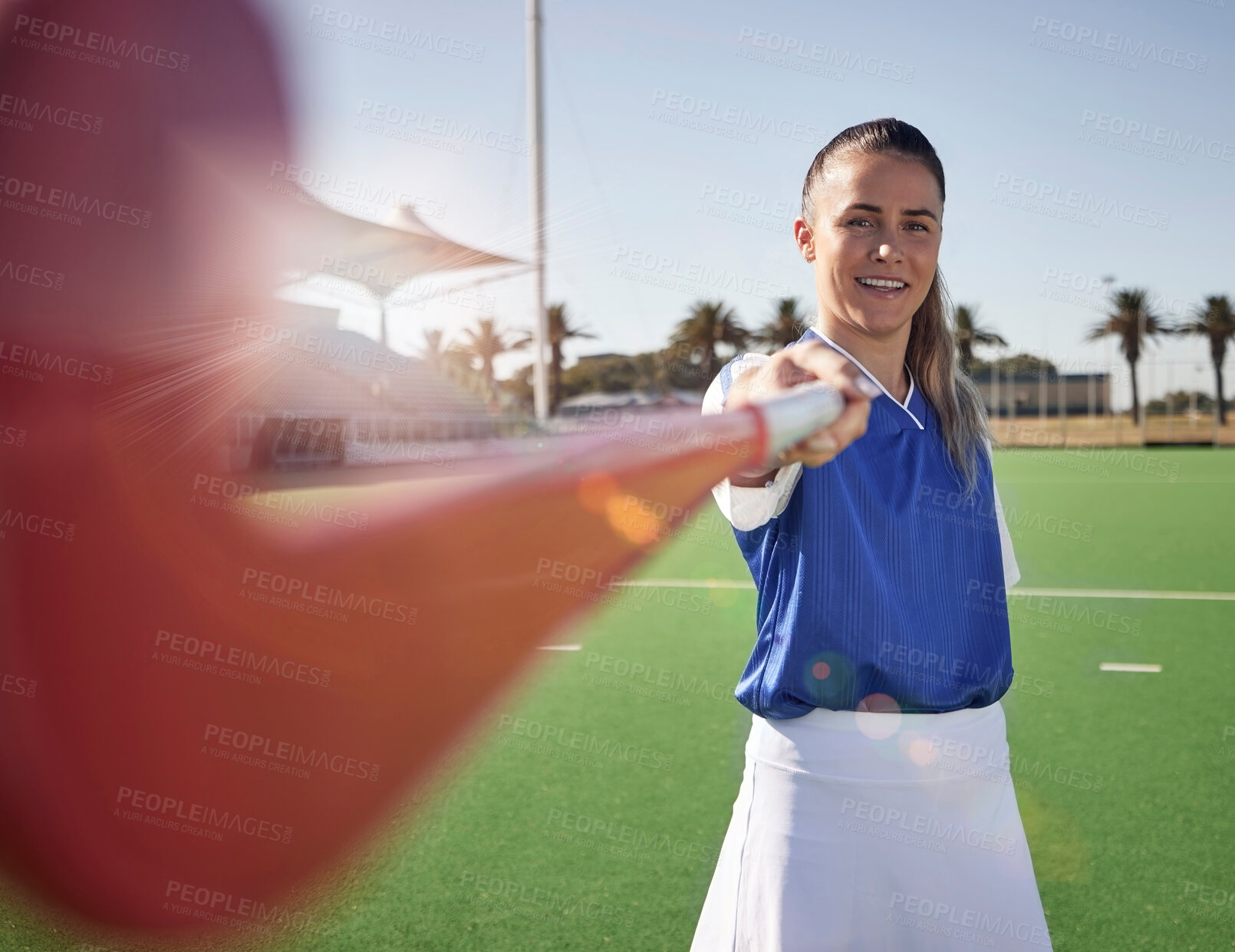 Buy stock photo Woman hockey player, closeup and portrait on field with smile, hockey stick and happy in sunshine. Hockey, outdoor and sport girl at training, exercise and workout in sports ground, arena or stadium