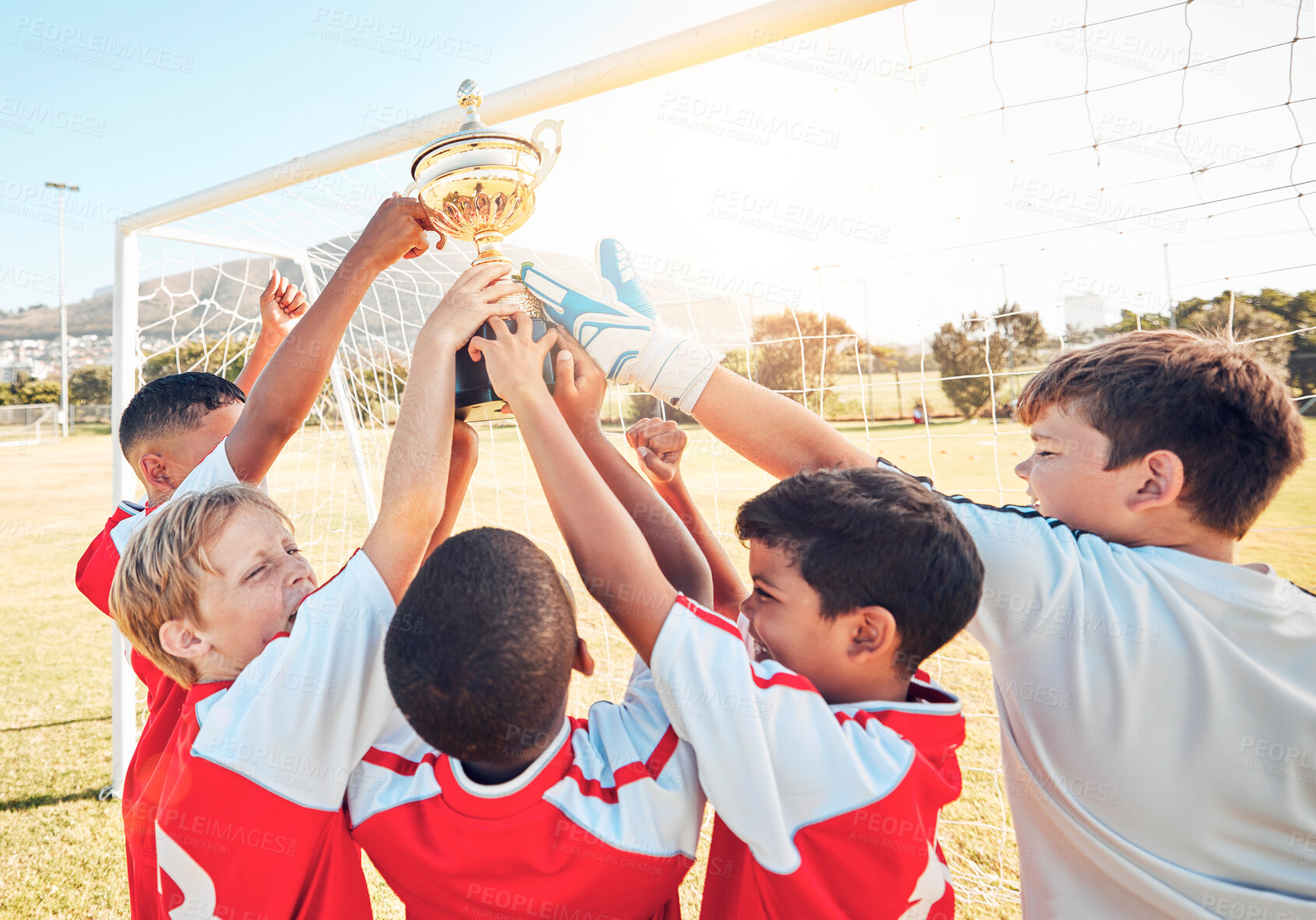 Buy stock photo Children, sports and trophy with a winner team in celebration of victory on a field or grass pitch outdoor. Soccer, health and award with a kids group cheering their sport achievement outside