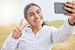 Woman runner, phone selfie and peace sign in nature, park or grass for social media after exercise. Girl, smartphone and smile in photo outdoor at training, running or workout in morning for web blog