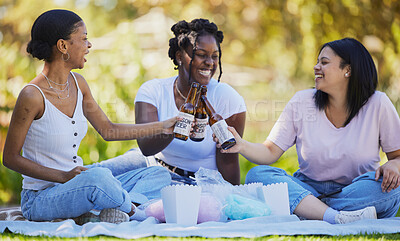 Buy stock photo Black women, picnic and beer toast in park, nature environment or sustainability garden with food, popcorn or cotton candy. Smile, happy friends or bonding students with alcohol in celebration social